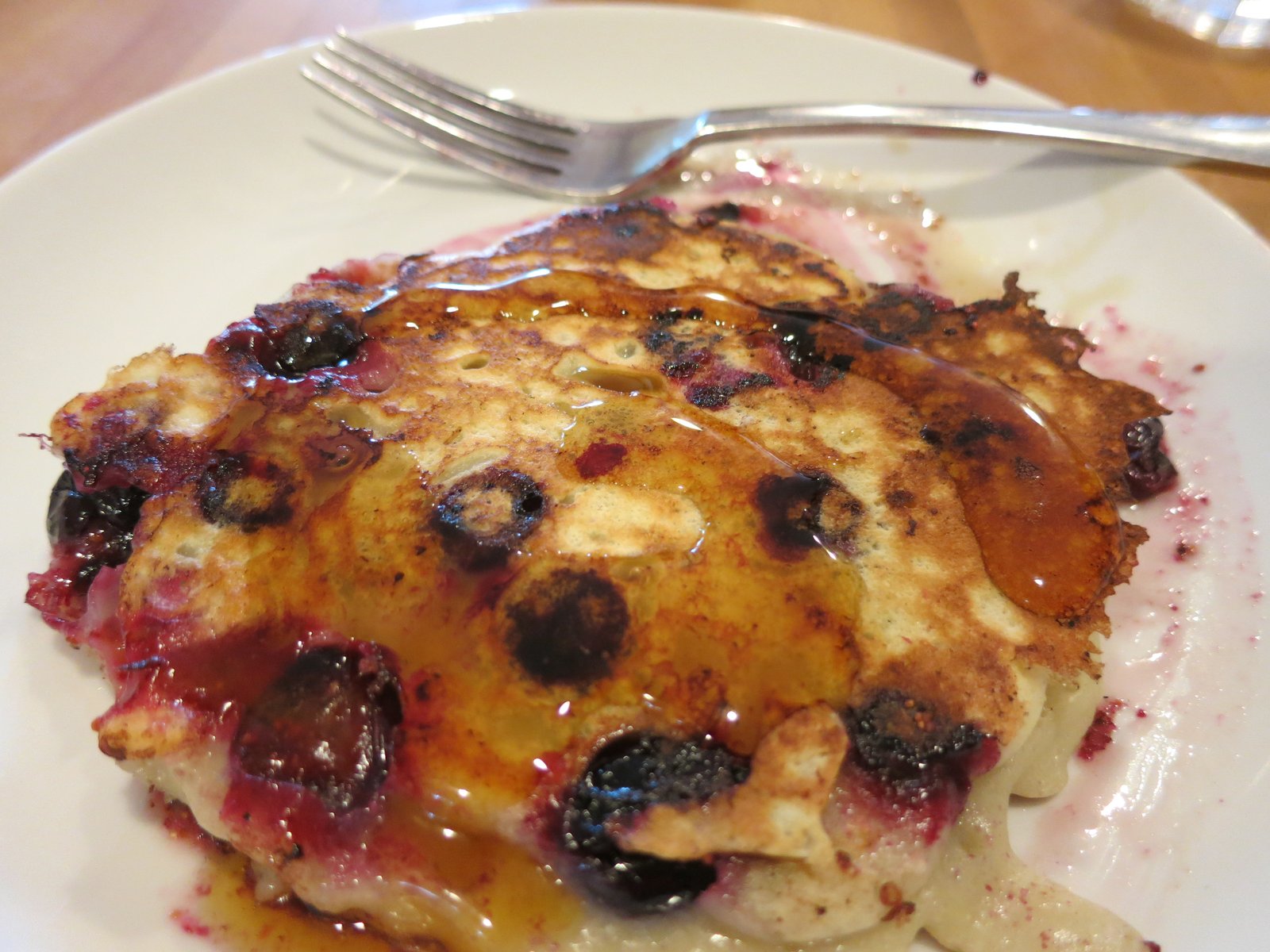 A stack of blueberry pancakes with maple syrup