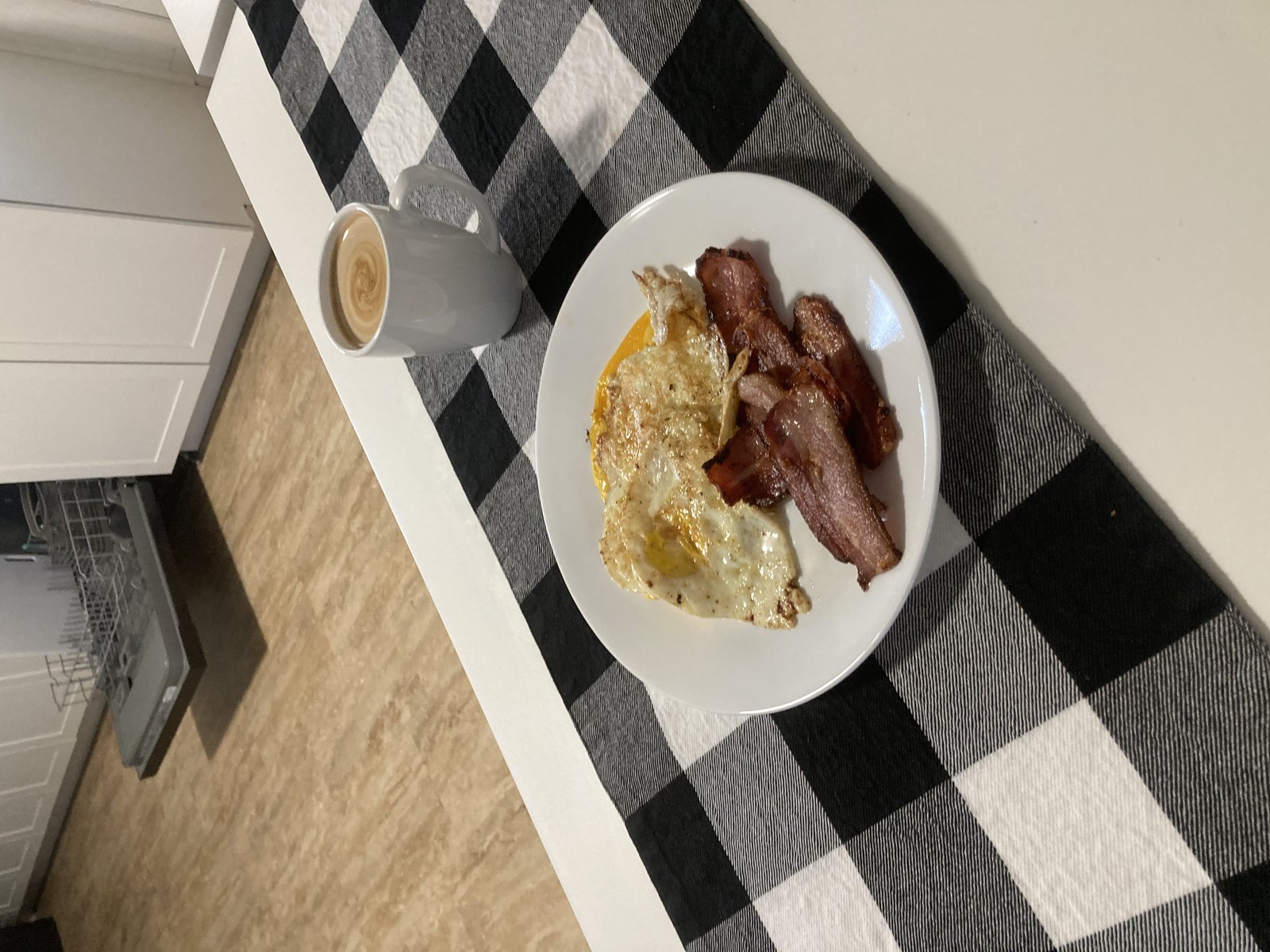 A home-style breakfast of fried eggs, bacon and coffee