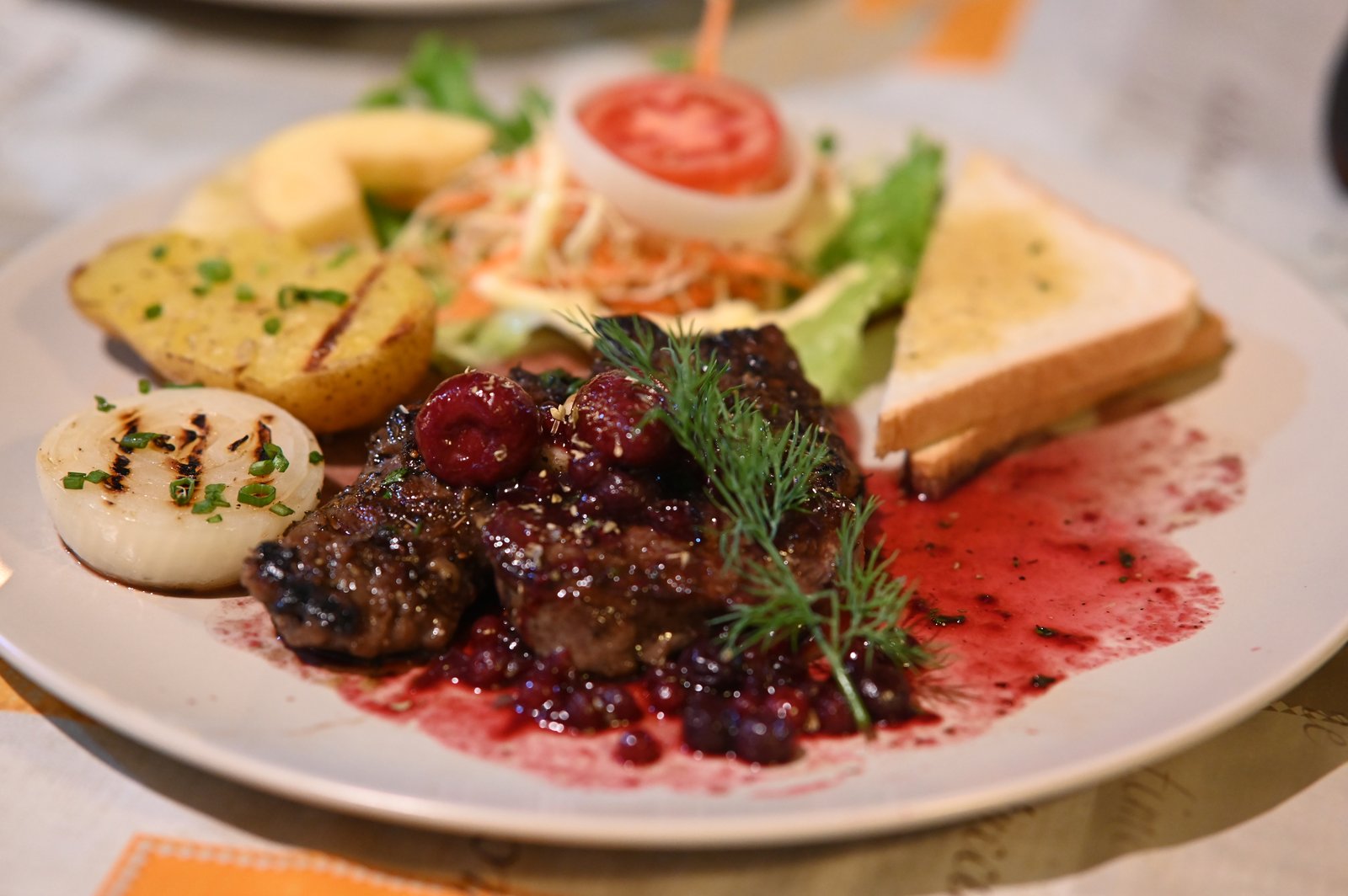 A plated fine-dining dish of seared steak medallions